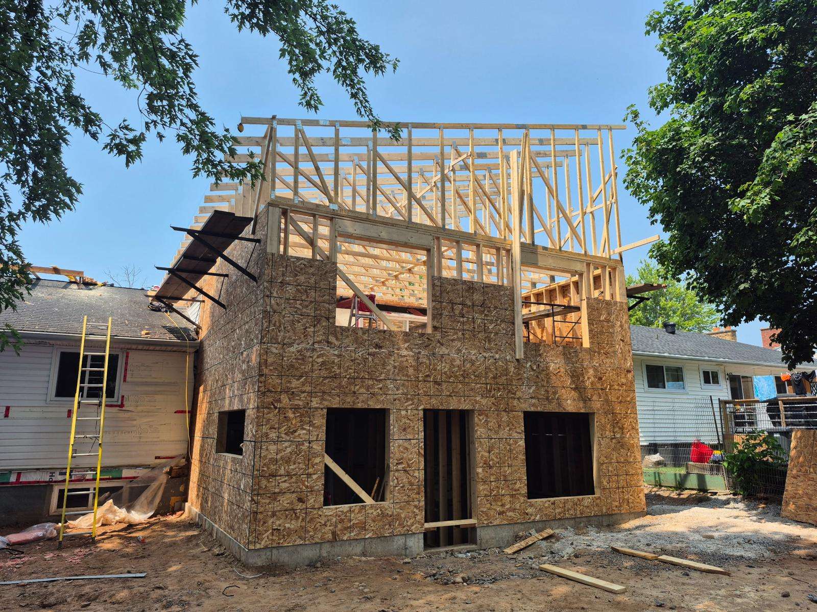 Roof trusses set and walls sheathed in OSB on a new second storey
