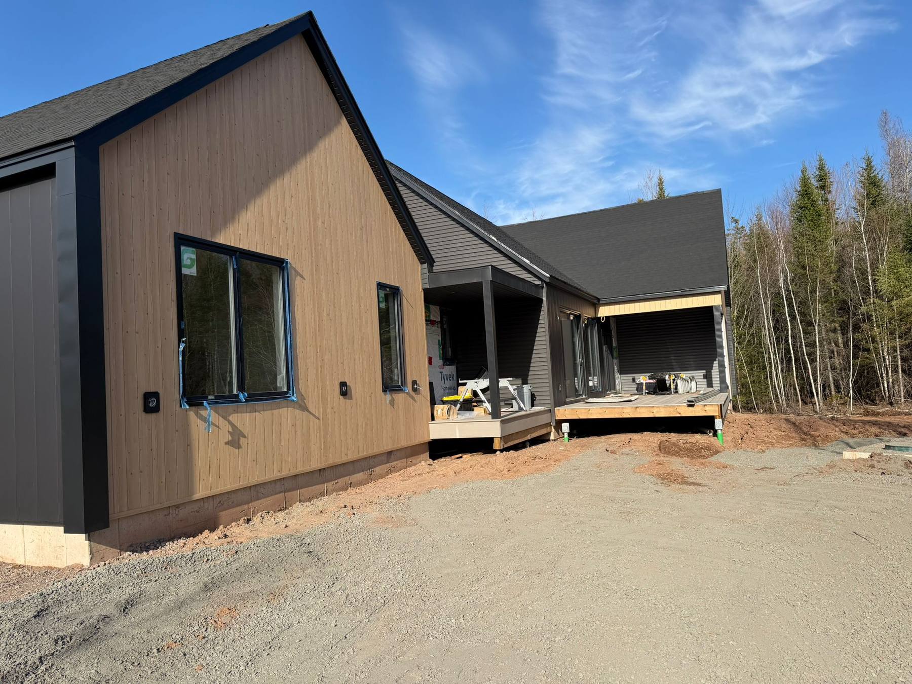 Completed custom home with board-and-batten siding and dark metal roof