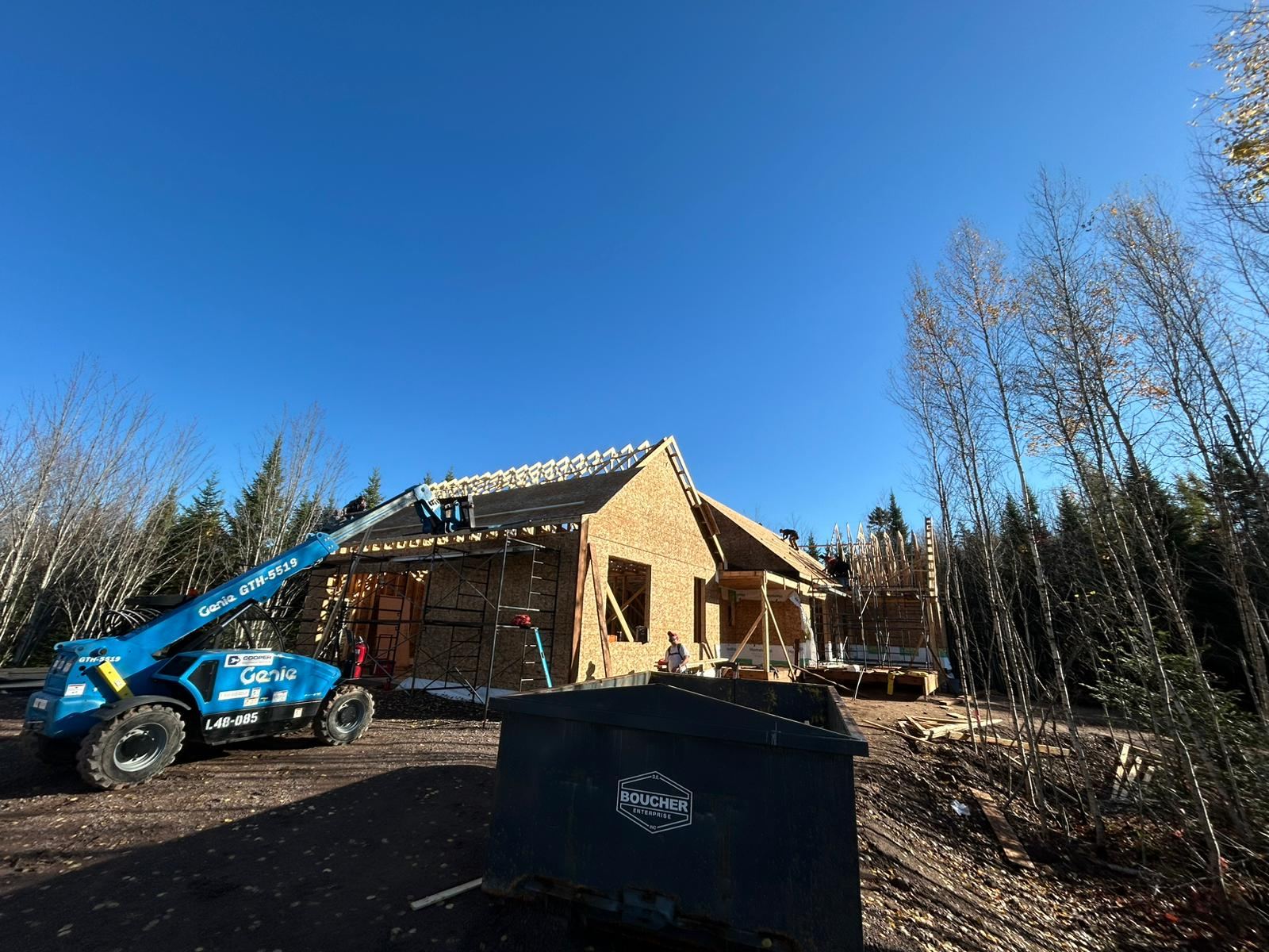 Custom home framed and sheathed, with the roof structure going on