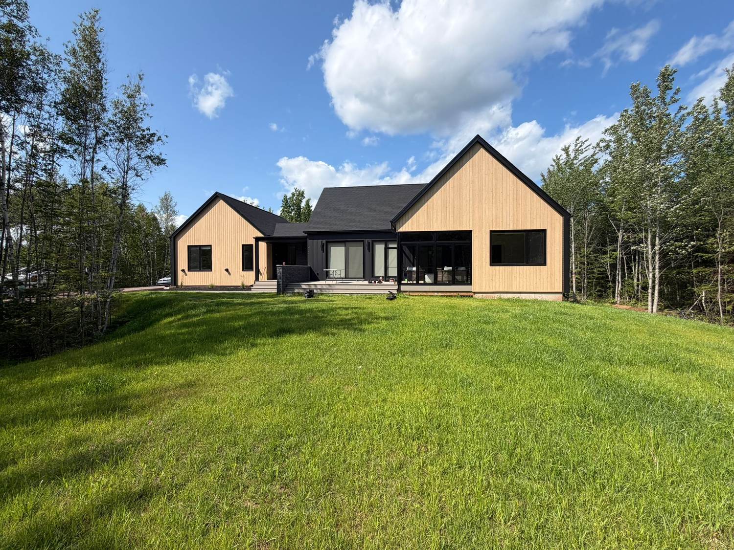 The finished custom home seen across the rear lawn