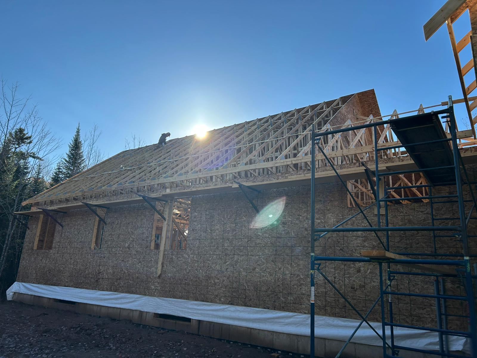 Roof trusses set and sheathed, scaffolding still in place