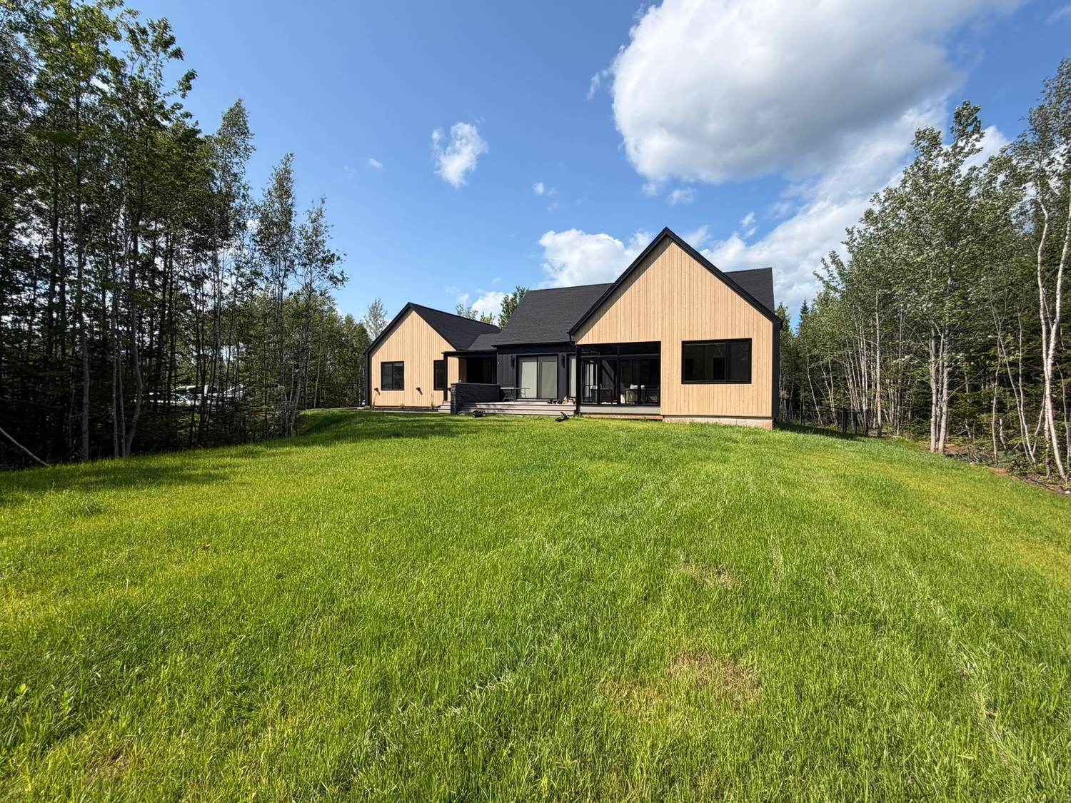 Completed custom home seen across the finished lawn